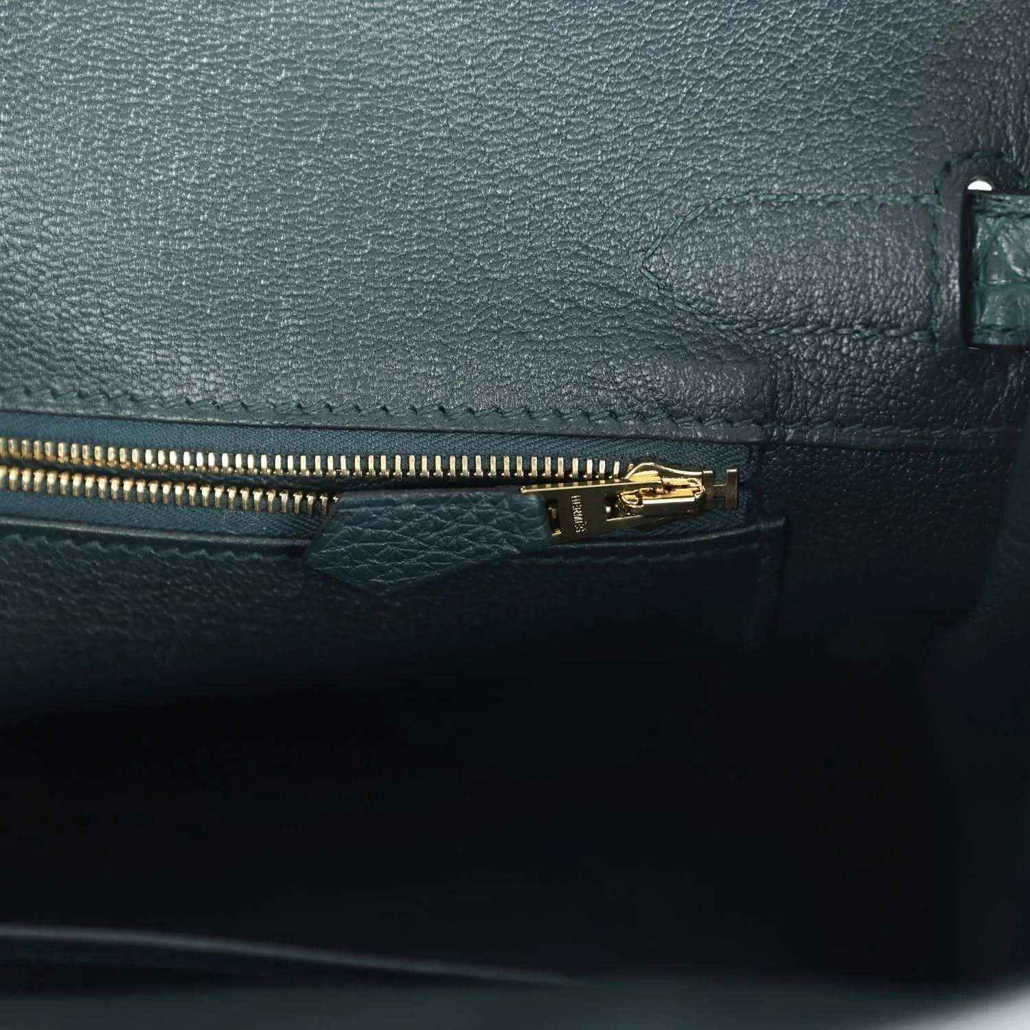 Elegant black leather handbag interior with gold zipper, showcasing refined, timeless style.