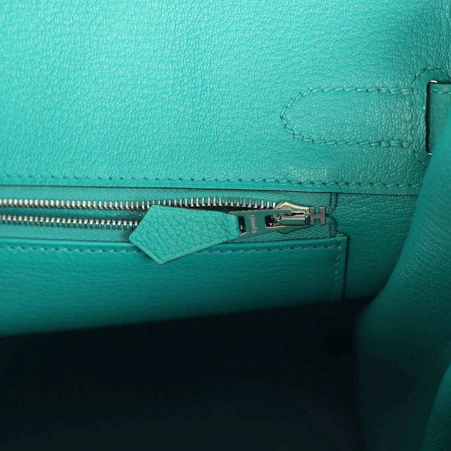 Timeless turquoise leather handbag interior with elegant silver zipper detail.