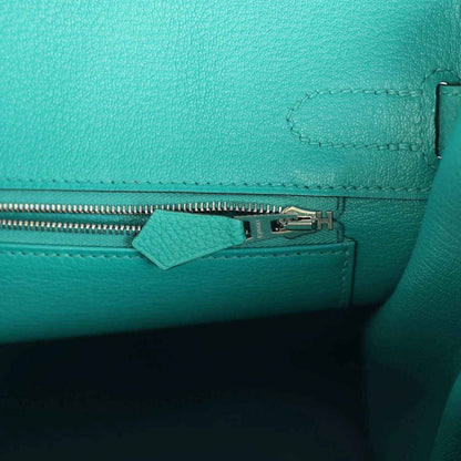 Timeless turquoise leather handbag interior with elegant silver zipper detail.