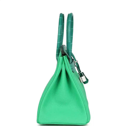Elegant green leather handbag with structured silhouette and sophisticated double handles