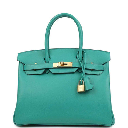 Elegant turquoise leather handbag with gold hardware and a timeless, sophisticated design