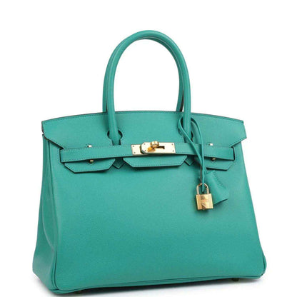 Elegant teal leather handbag with gold hardware, featuring a sophisticated, timeless design.