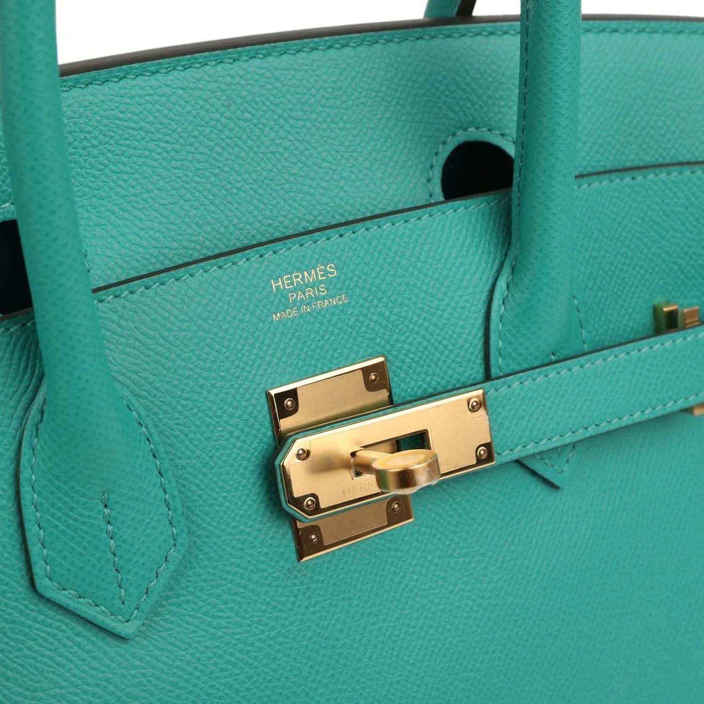 Timeless turquoise leather handbag with elegant gold hardware and refined details.
