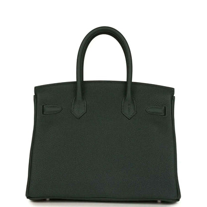Timeless dark green leather handbag with structured silhouette and elegant top handles.