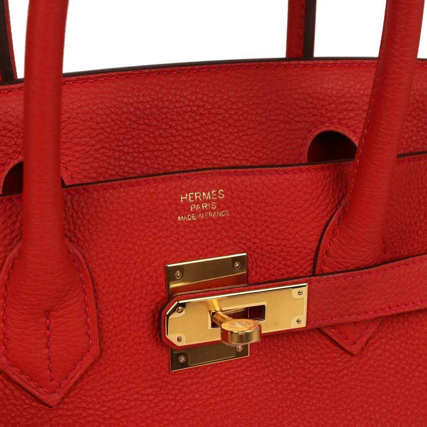 Elegant red leather handbag with gold hardware and refined detailing, a timeless luxury accessory.