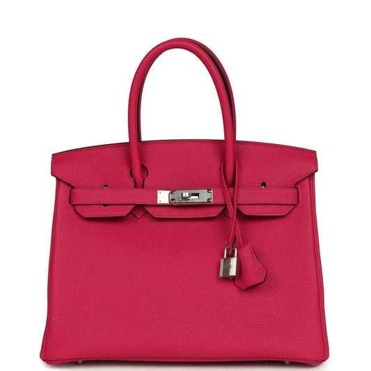 Elegant fuchsia leather handbag with silver hardware and a timeless, sophisticated design.
