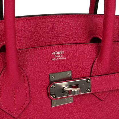 Elegant, timeless red leather handbag with silver hardware and sophisticated textured finish.