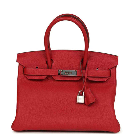 Elegant red leather handbag with silver hardware, structured and timeless design for women