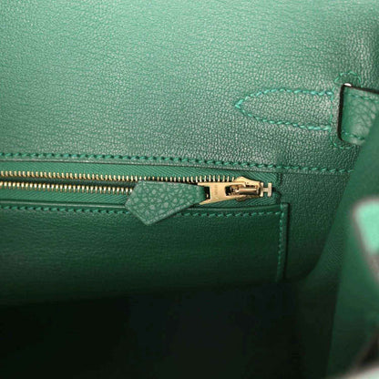 Elegant green leather handbag interior with gold zipper and refined stitching
