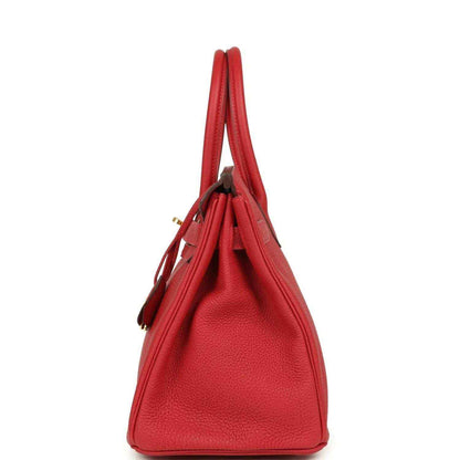 Elegant red leather handbag with pebbled texture and structured silhouette, side view