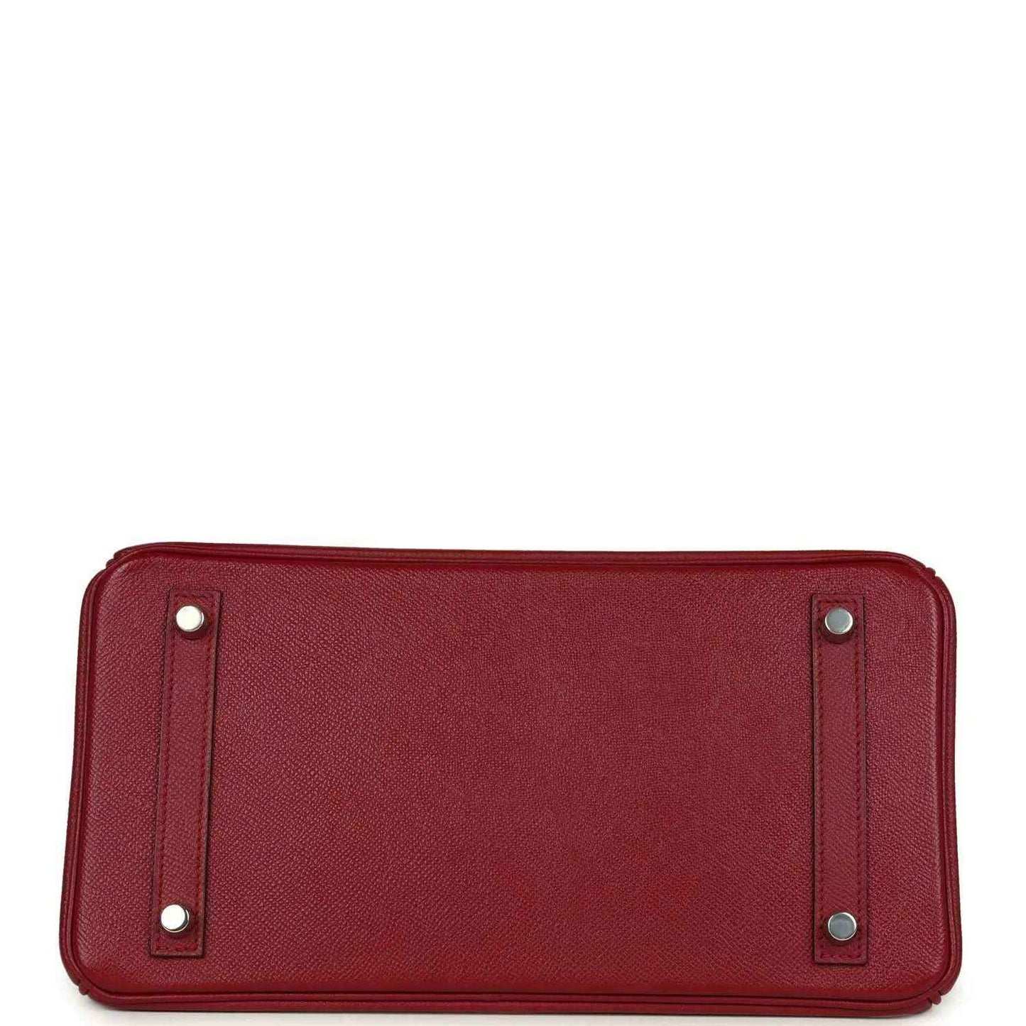 Bottom view of a timeless, elegant red leather handbag with silver feet and refined texture