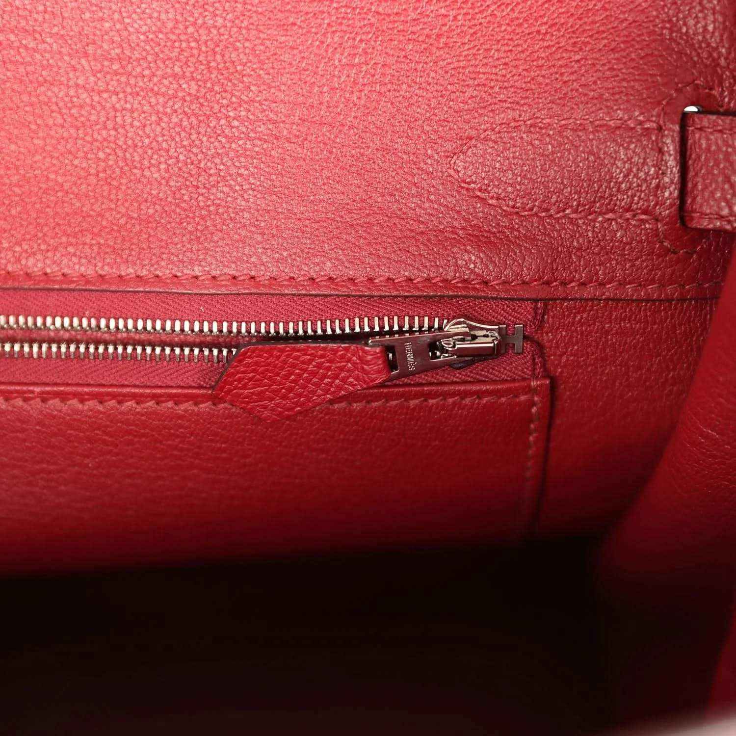 Elegant red leather handbag interior with refined zipper pocket and textured finish