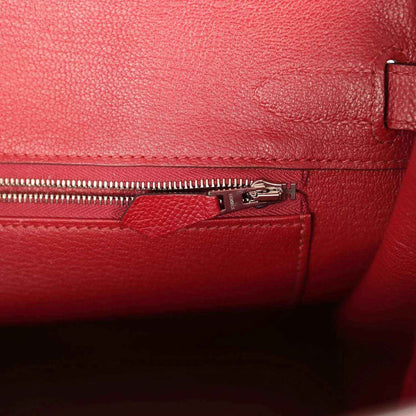 Elegant red leather handbag interior with refined zipper pocket and textured finish