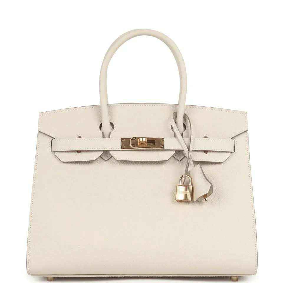 Timeless ivory leather handbag with gold hardware and elegant structured design.