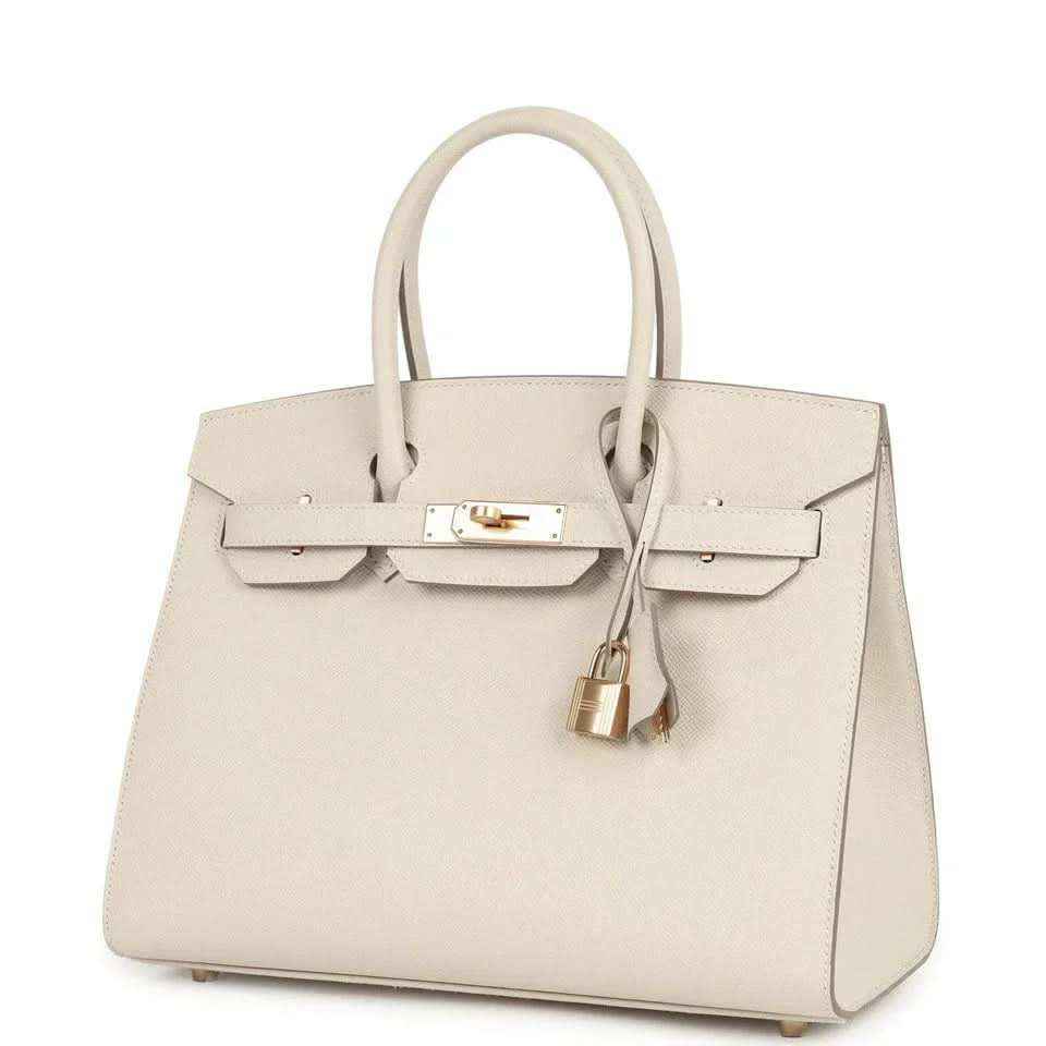 Timeless elegant ivory leather handbag with gold hardware and structured silhouette