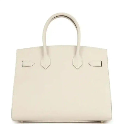 Timeless cream leather handbag with elegant top handles and sophisticated structured silhouette.