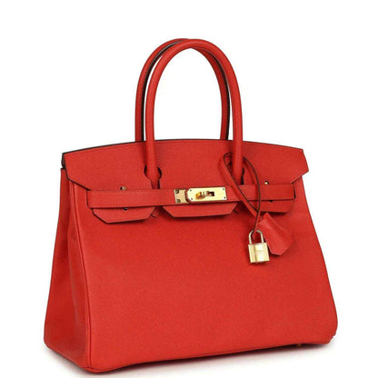Elegant red leather handbag with gold hardware and structured, timeless silhouette