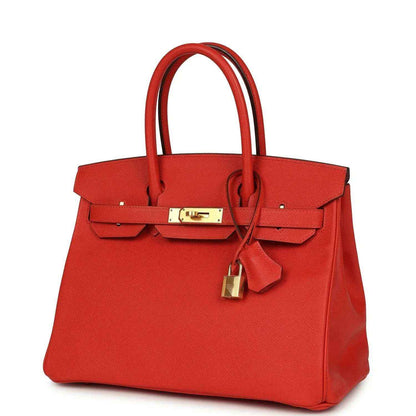 Timeless red leather handbag with elegant gold hardware and structured silhouette.