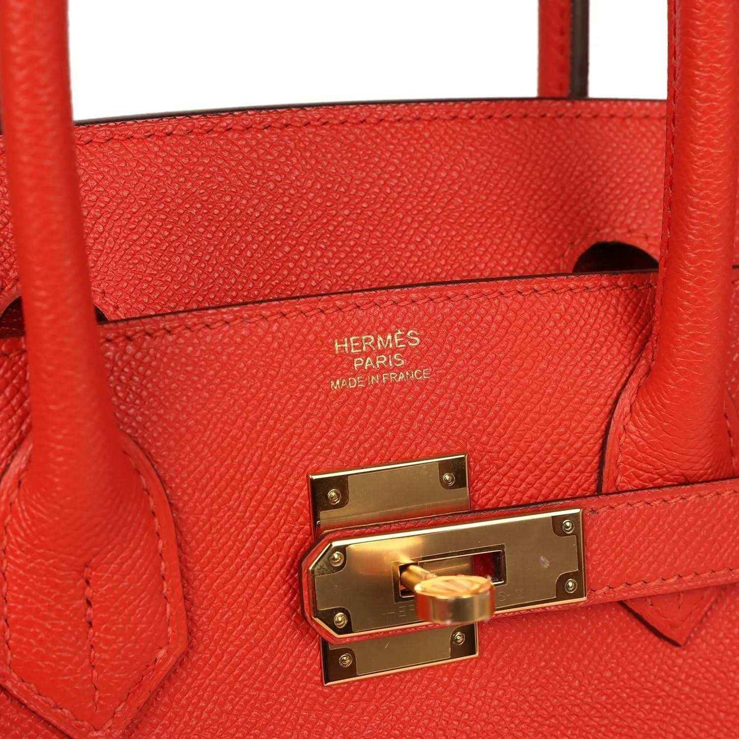 Timeless red leather handbag with gold hardware and elegant textured finish.