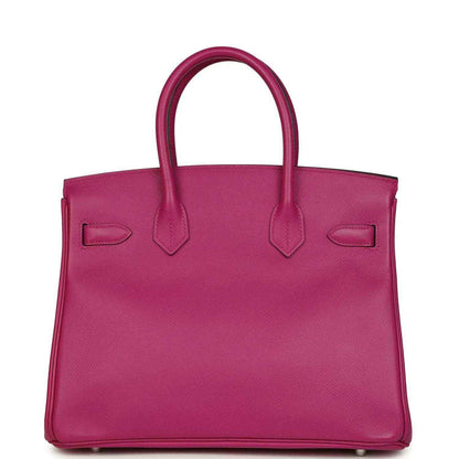 Elegant magenta leather tote handbag with a timeless, sophisticated silhouette.