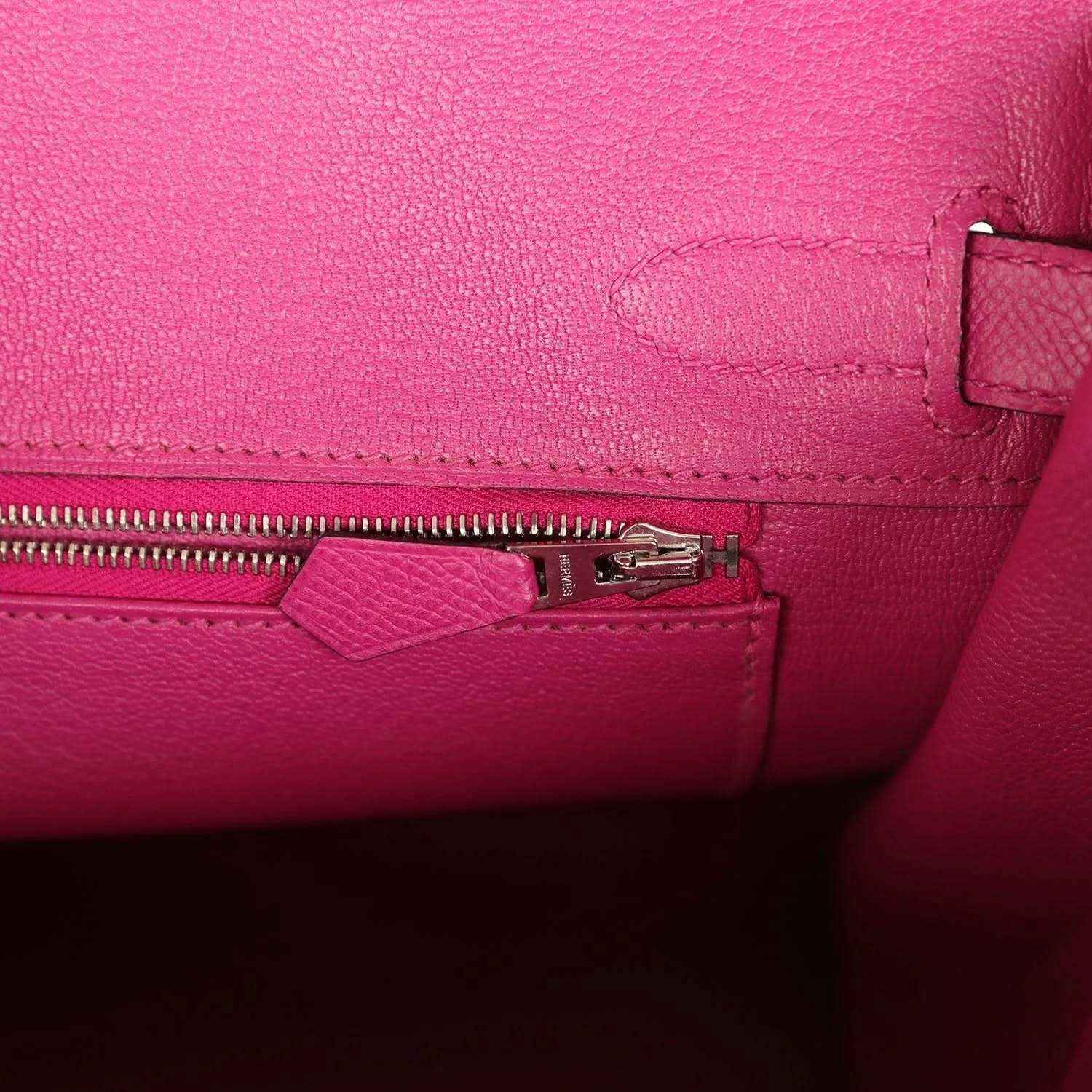 Elegant hot pink leather handbag interior with fine stitching and a silver zipper pocket.