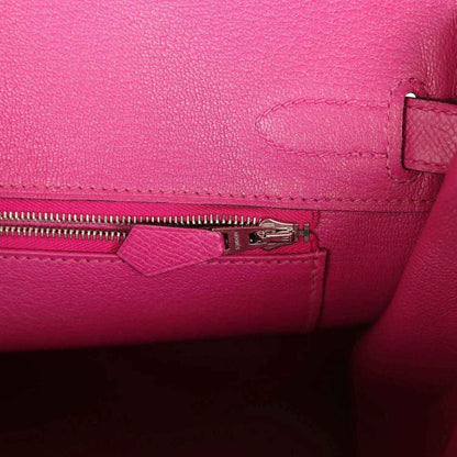 Elegant hot pink leather handbag interior with fine stitching and a silver zipper pocket.
