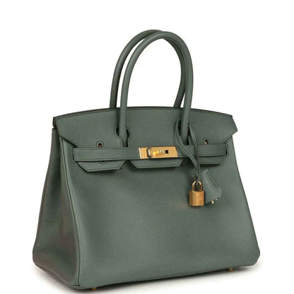 Elegant sage green leather handbag with gold hardware, featuring a timeless, sophisticated design.