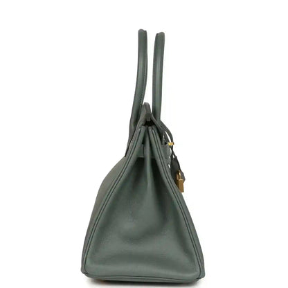Timeless, elegant green leather handbag with gold accents and a structured silhouette