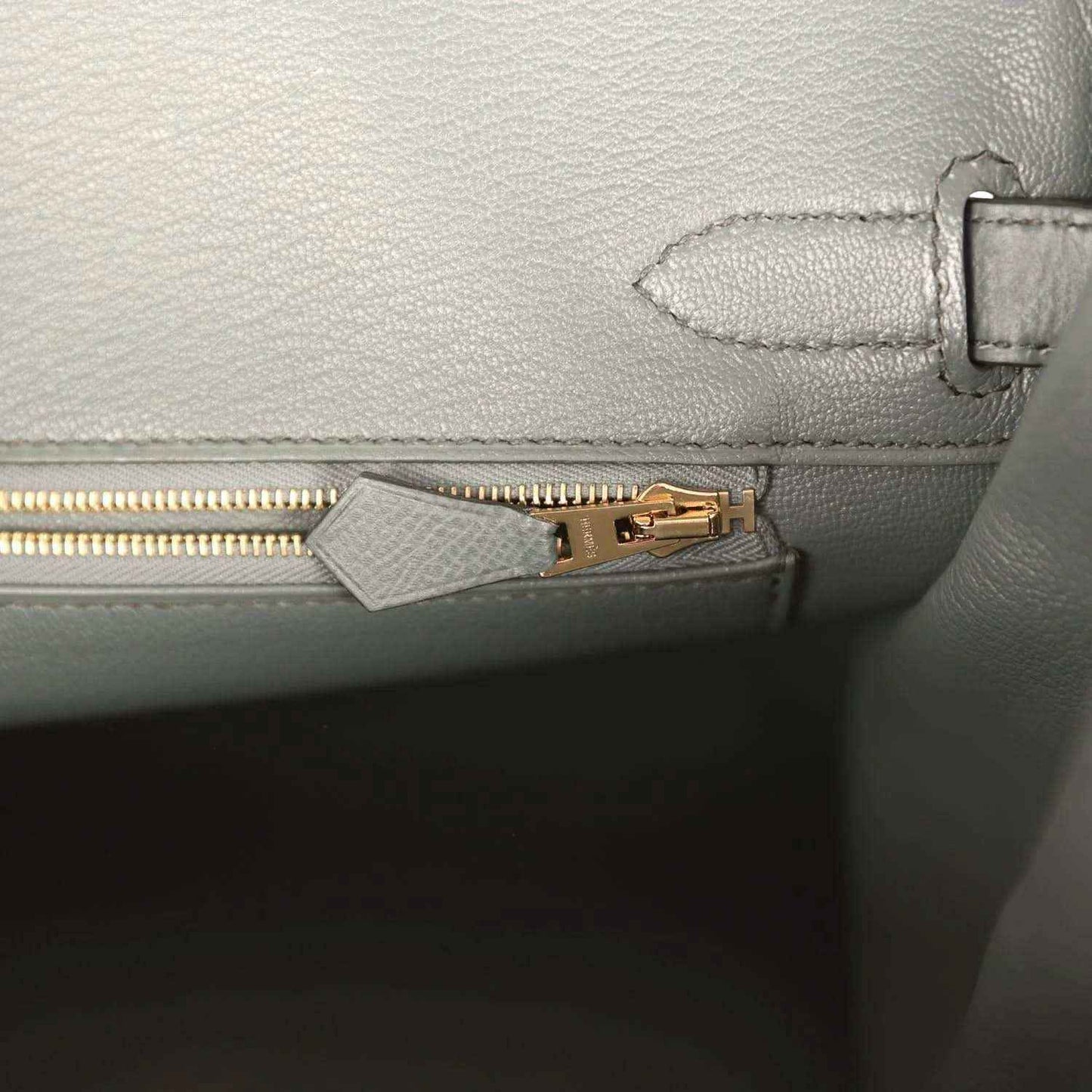 Elegant grey leather handbag with gold zipper and refined stitching, timeless and sophisticated.