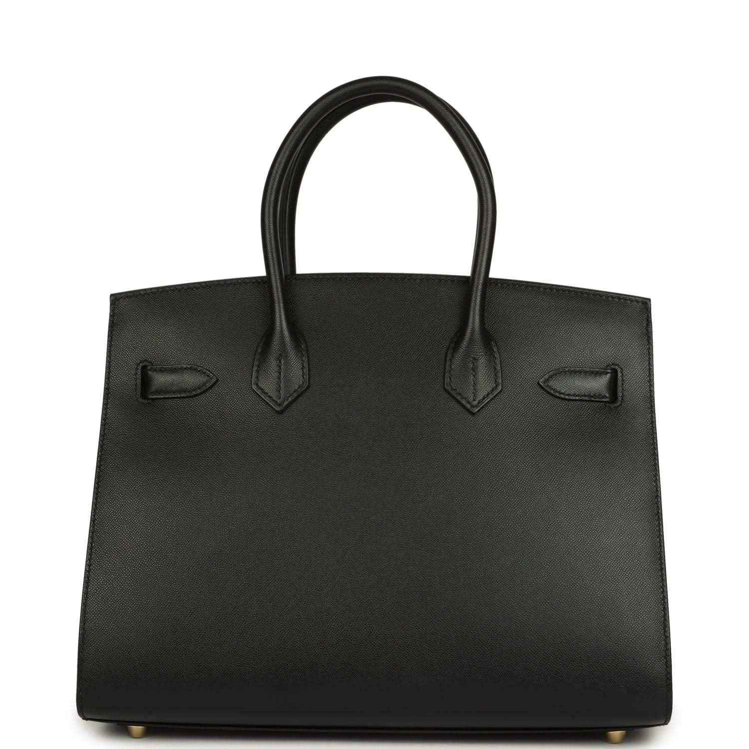 Timeless black leather handbag with elegant structured silhouette and refined handles.