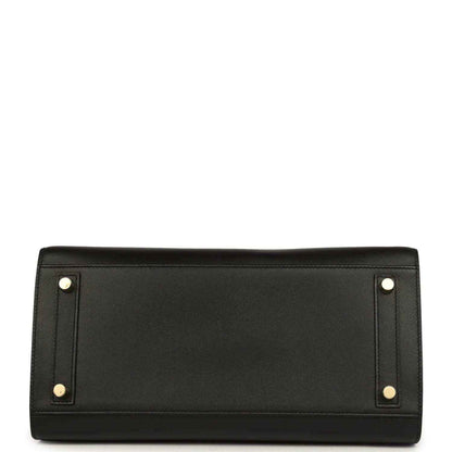 Timeless black leather handbag with elegant gold-tone feet and refined, sophisticated finish.