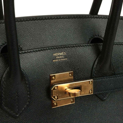 Elegant black leather handbag with gold hardware and sophisticated detailing