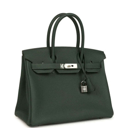 Elegant dark green leather handbag with silver hardware, timeless and sophisticated style.