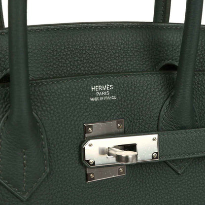 Timeless dark green leather handbag with elegant silver hardware and refined grain texture.