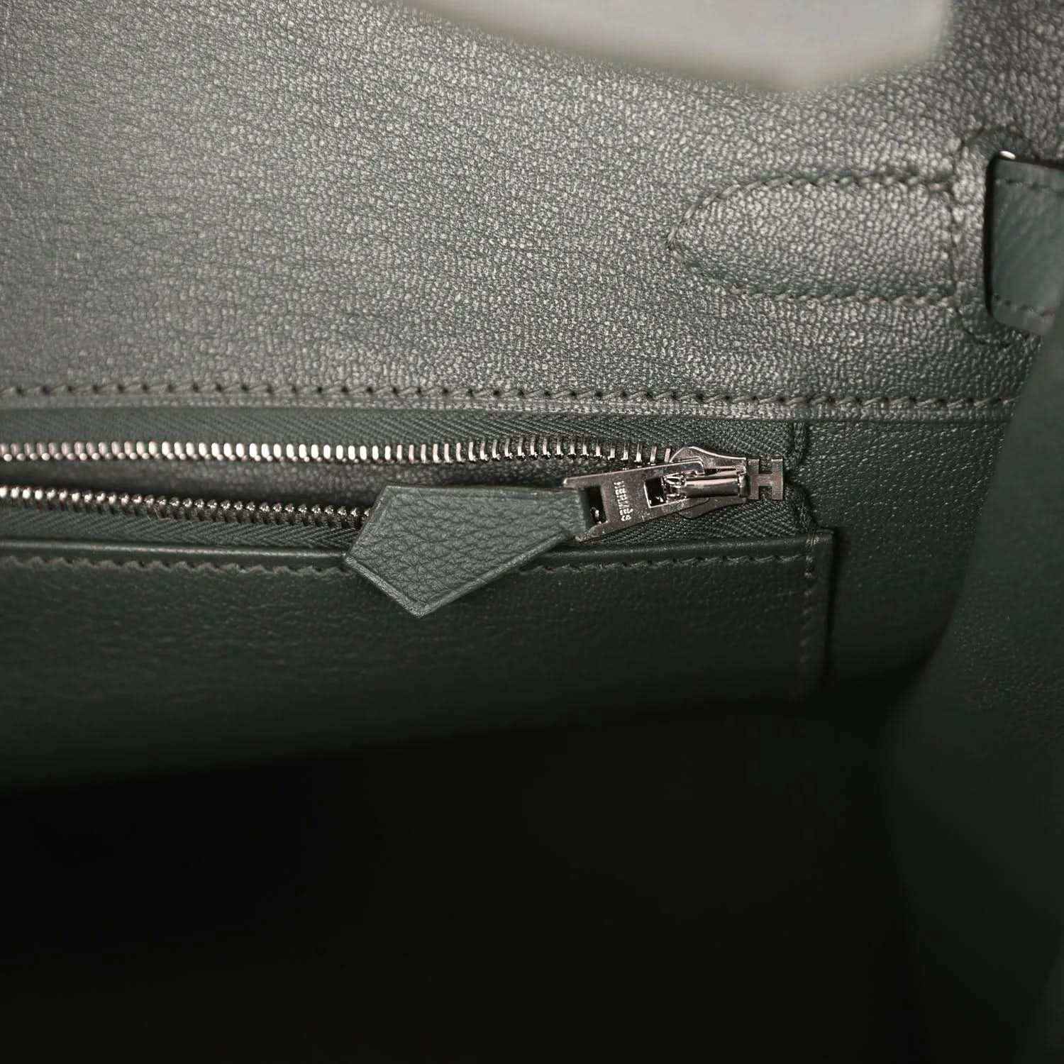 Elegant dark green leather handbag interior with refined zipper detail