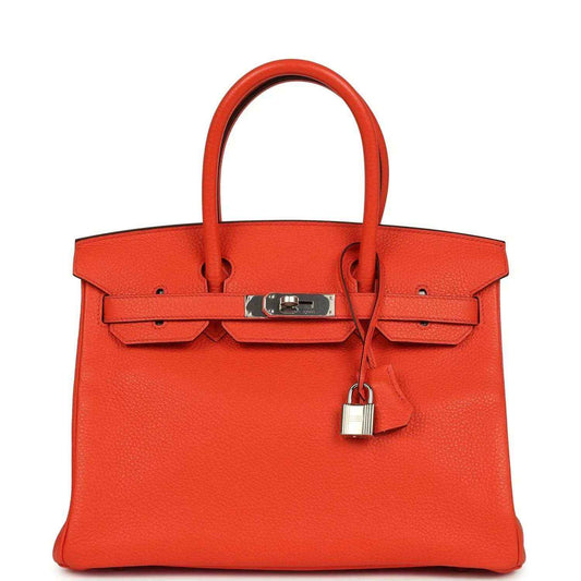 Timeless, elegant orange leather handbag with silver hardware and a sophisticated silhouette.