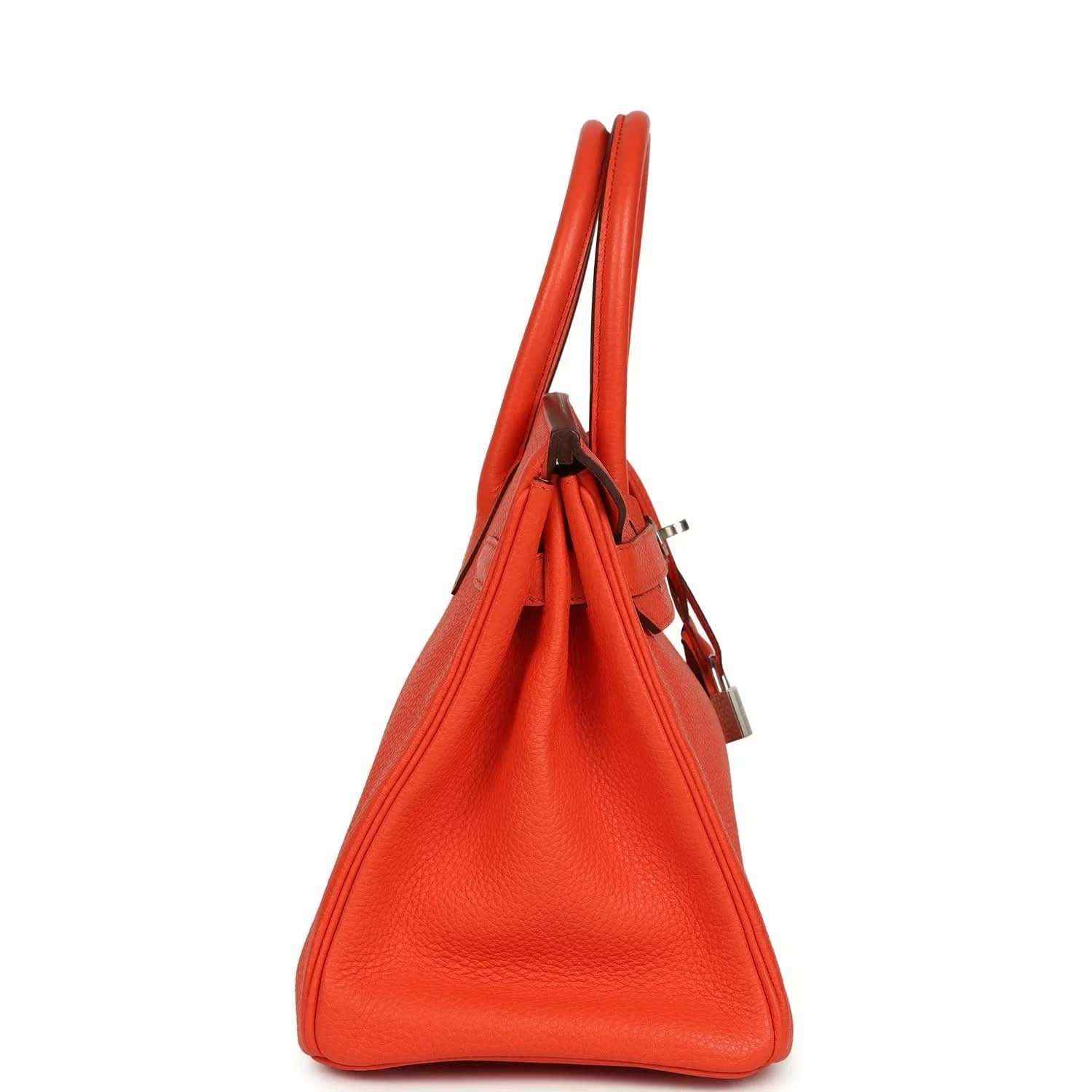 Elegant orange leather handbag with refined texture and structured, timeless silhouette