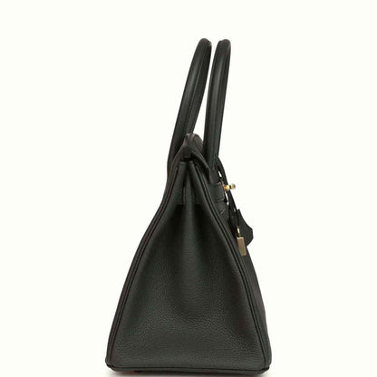Elegant black leather handbag with gold accents, featuring timeless and sophisticated design