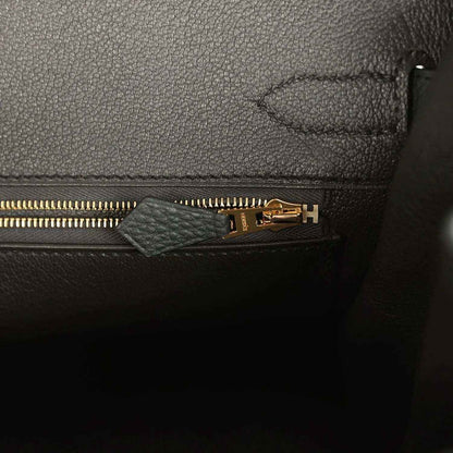 Elegant black leather handbag interior with gold zipper and refined stitching detail