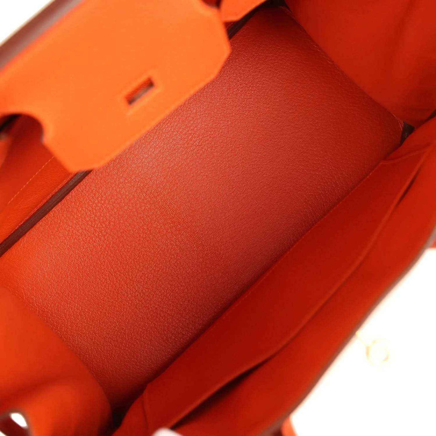Interior of an elegant orange leather handbag with refined, sophisticated detailing