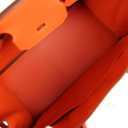 Interior of an elegant orange leather handbag with refined, sophisticated detailing