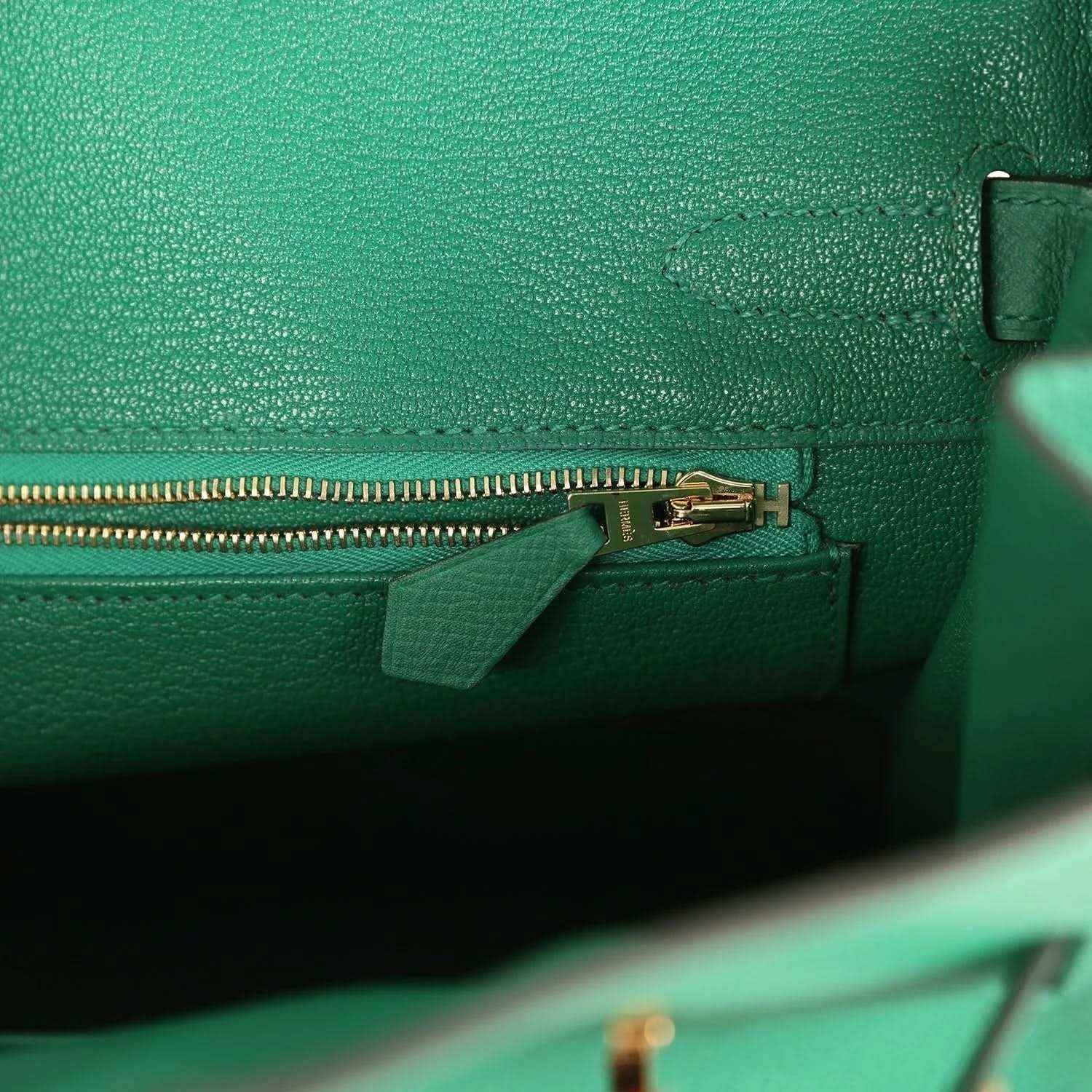 Elegant green leather handbag interior with gold zipper and refined detailing