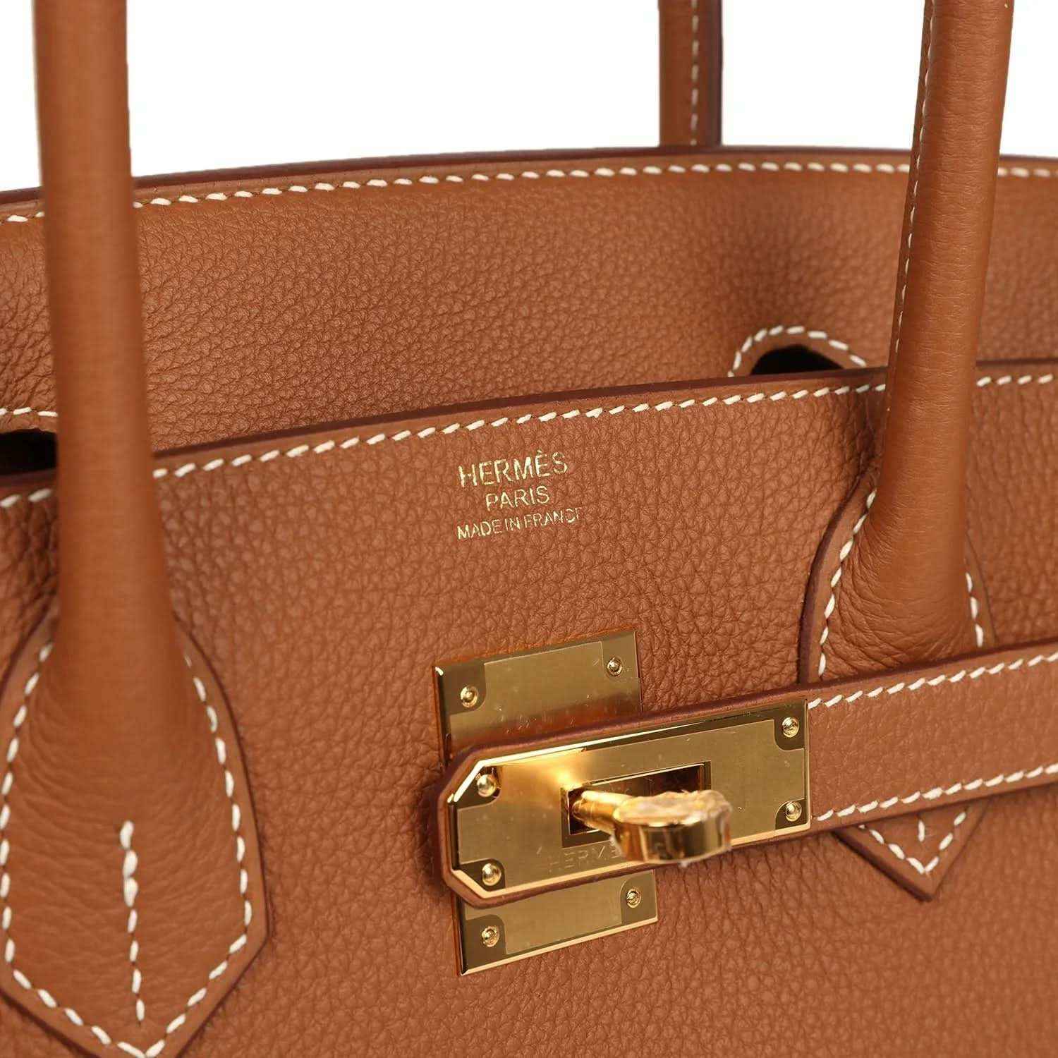 Elegant tan leather tote bag with gold hardware and white stitching, timeless and sophisticated