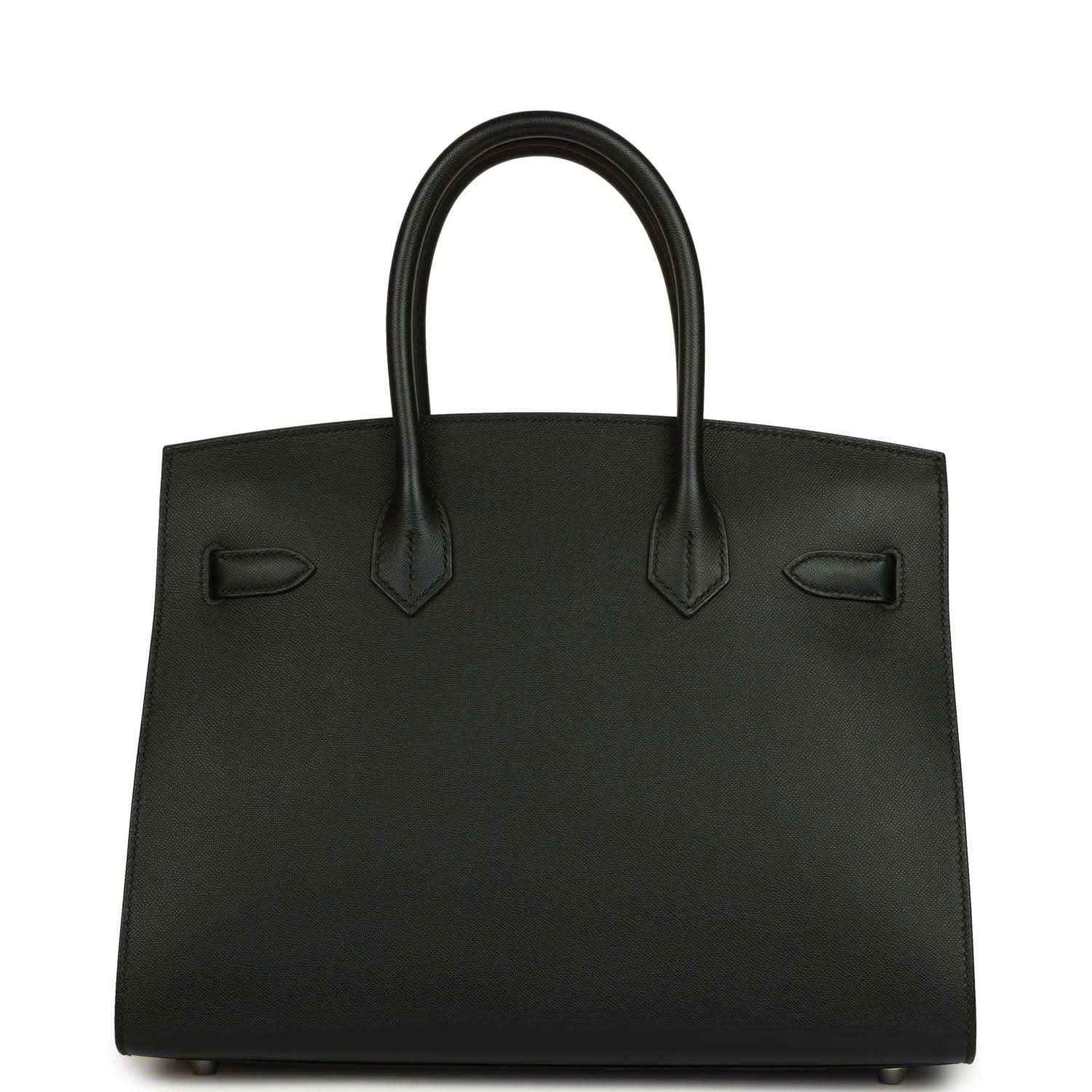 Timeless black leather handbag with elegant structured silhouette and refined finishing.