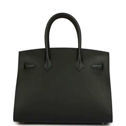 Timeless black leather handbag with elegant structured silhouette and refined finishing.