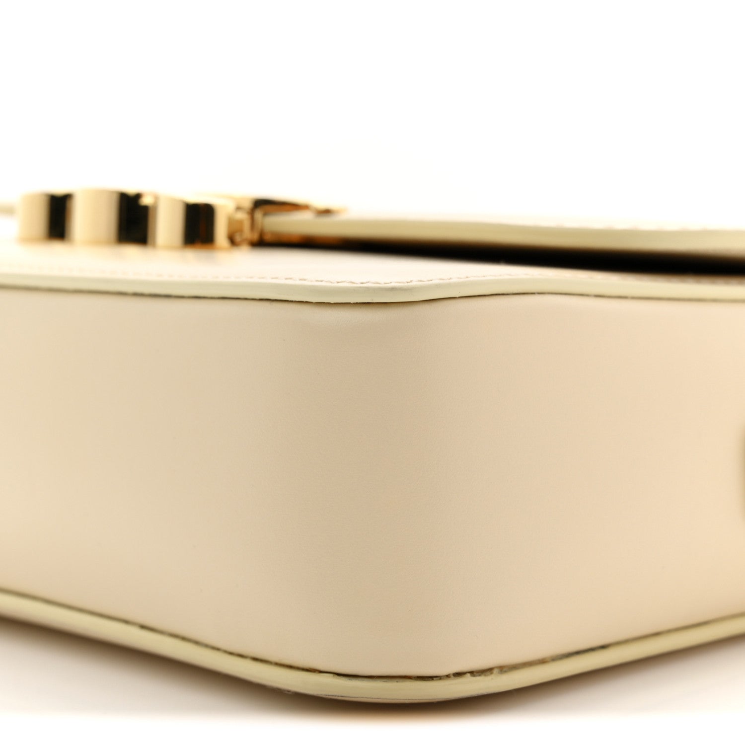 Close-up of gold top clasp and nude mini bag corner