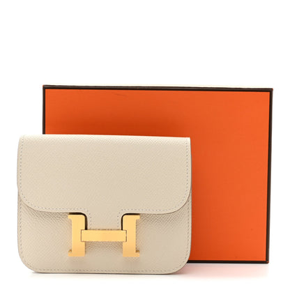 Slim wallet with flap and gold H clasp, light cream textured leather in orange box