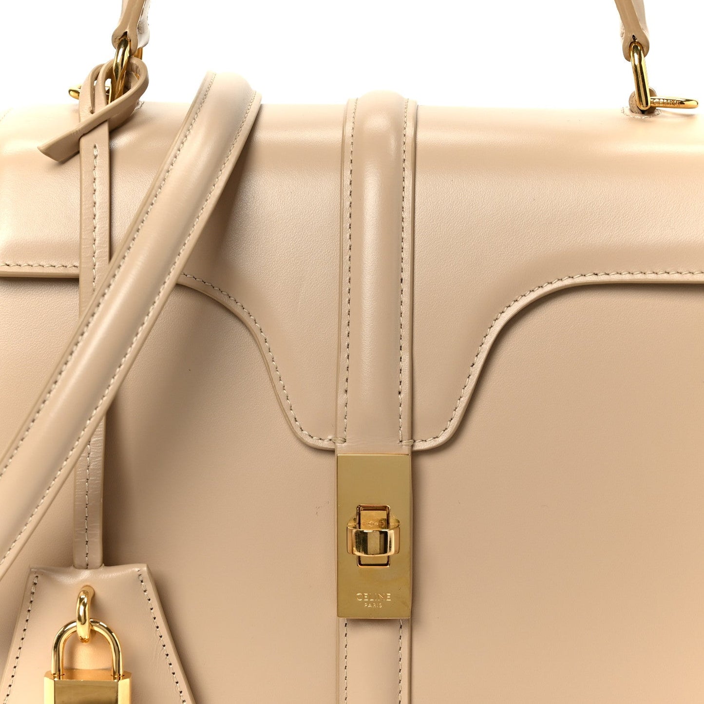 Nude small top-handle bag with gold buckle and leather strap close-up