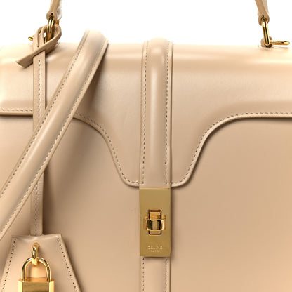 Nude small top-handle bag with gold buckle and leather strap close-up