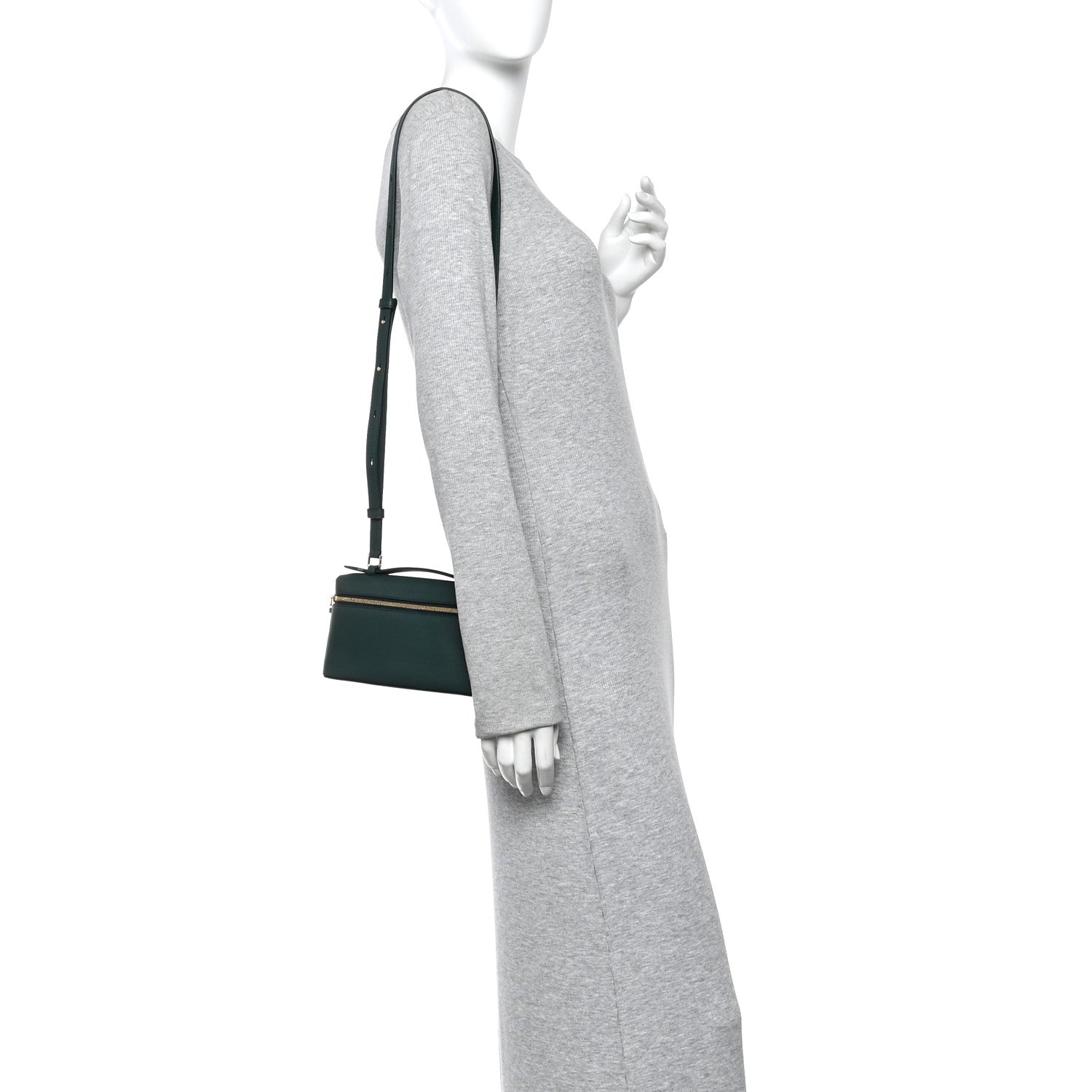 Dark green leather crossbody pouch with adjustable strap, worn at the side.